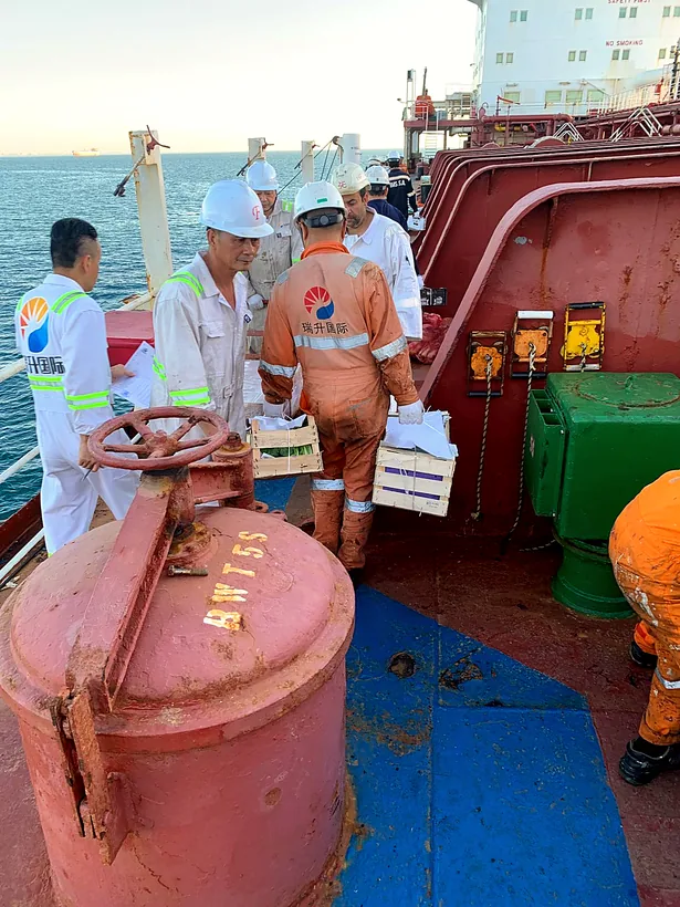 Crew in safety gear taking delivery of supplies on deck